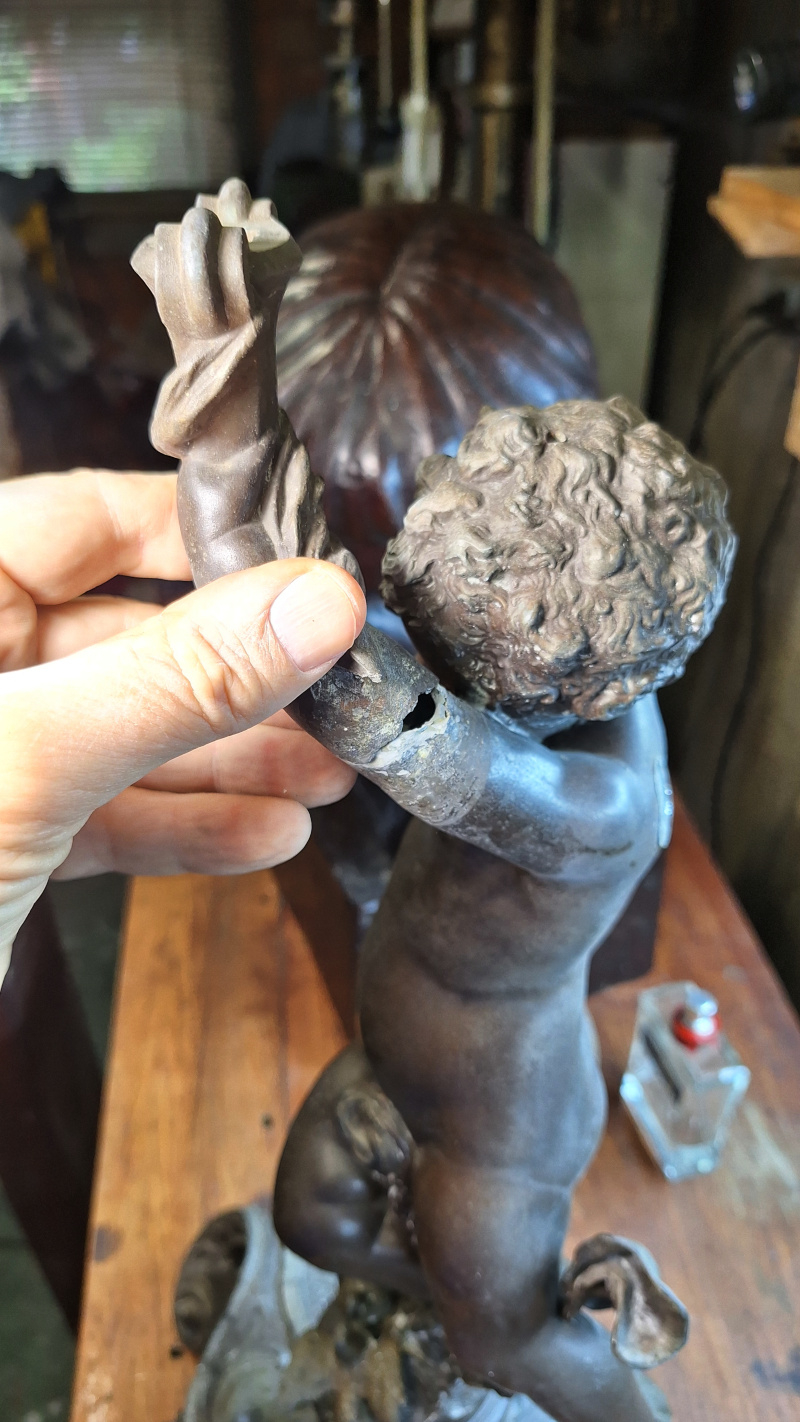 restaura&ccedil;&atilde;o bra&ccedil;o de uma estatueta de cupido em estanho peda&ccedil;os faltantes provavelmente da primeira quebra